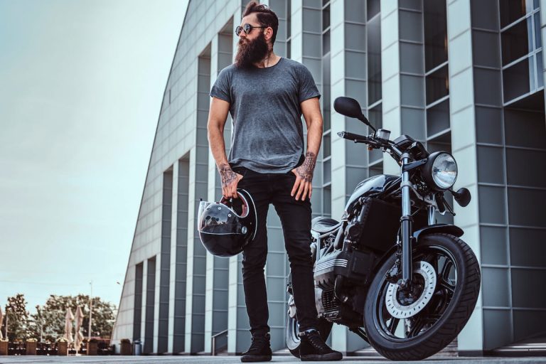 man standing next to motorcycle